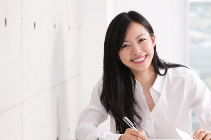 A young woman smiling at her desk